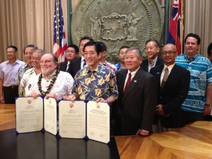 Govs. Abercrombie and Nakamura flanked by Rep. Ken Ito, Sen. Will Espero and DBEDT Director Richard Lim show off the reaffirmation documents.